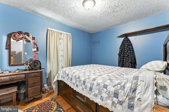 a bedroom with a bed and a mirror on dresser