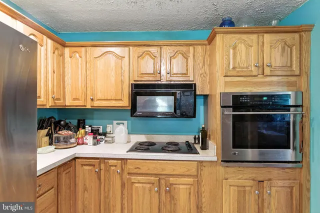 a kitchen with stainless steel appliances granite countertop a stove microwave and cabinets