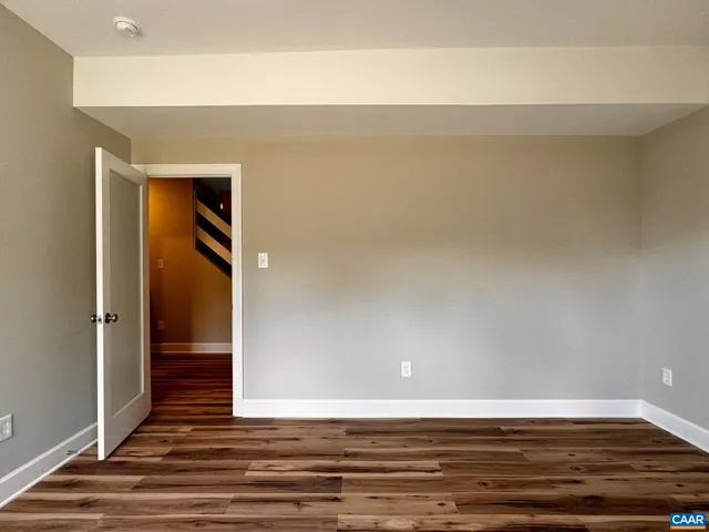 a view of a hallway with wooden floor and closet