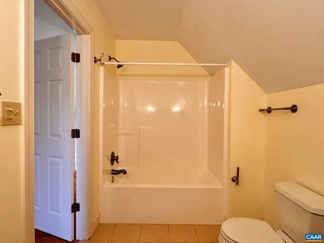 a view of a house with a small yard and wooden fence
