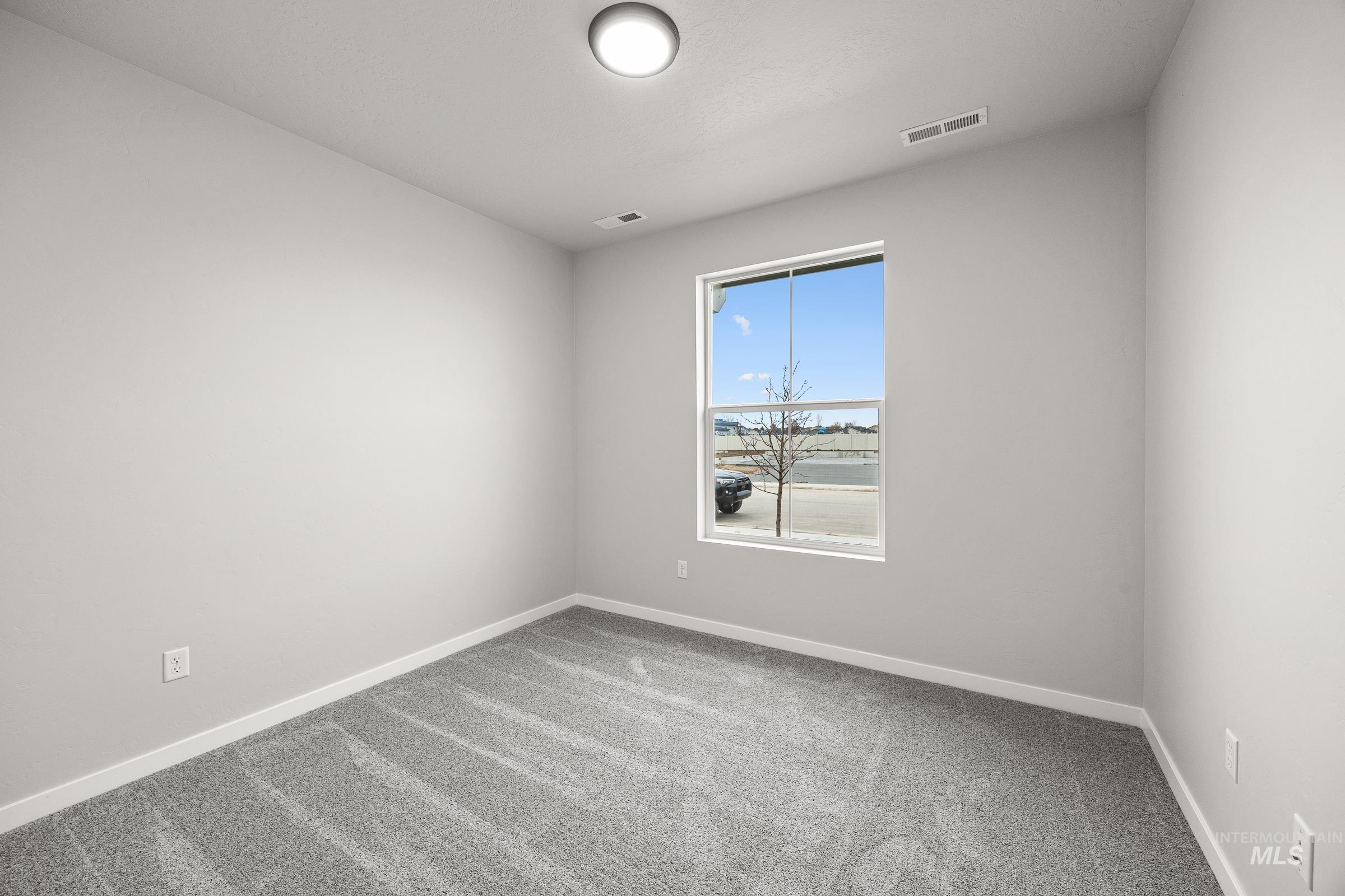 13656 Redway Court Caldwell, ID 83607 - Photo 16 of 21 Neutral tone carpeting in a room with light-colored walls and a window with blinds