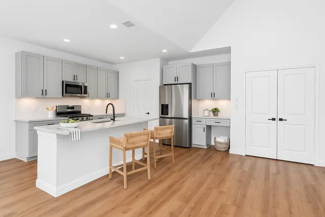 a kitchen with white cabinets and stainless steel appliances