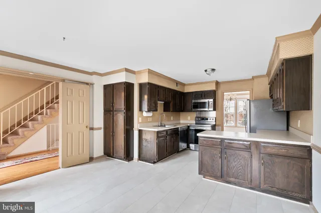 a kitchen with stainless steel appliances a refrigerator and a stove top oven