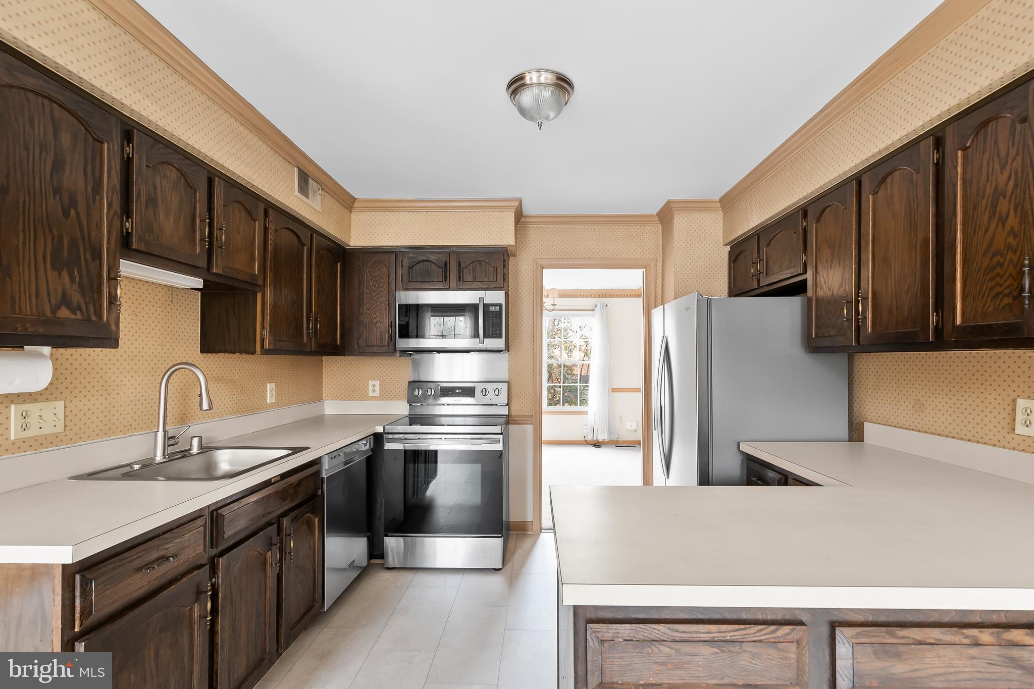 9518 Hunt Square Court Springfield, VA 22153 - Photo 17 of 39 a kitchen with stainless steel appliances granite countertop a stove refrigerator sink and cabinets