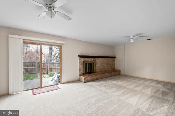 a view of an empty room with a fireplace and a window