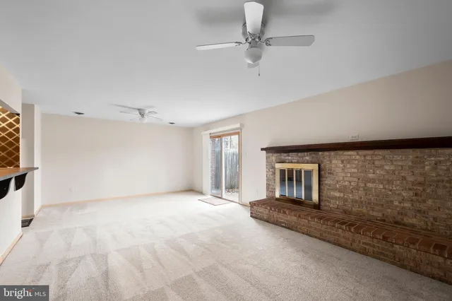 a view of an empty room with a fireplace and a window