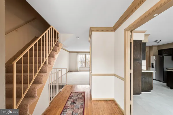 a view of a hallway with wooden floor and staircase