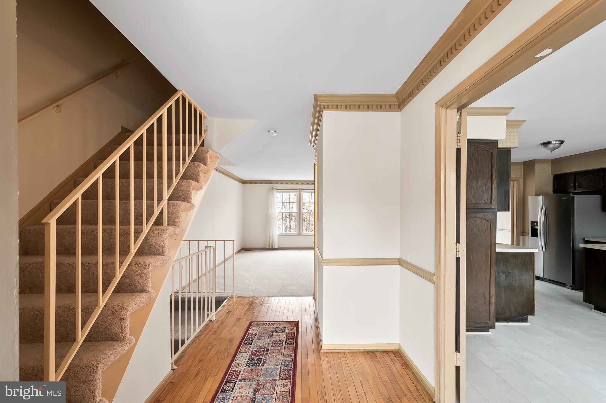 9518 Hunt Square Court Springfield, VA 22153 - Photo 5 of 39 a view of a hallway with wooden floor and staircase