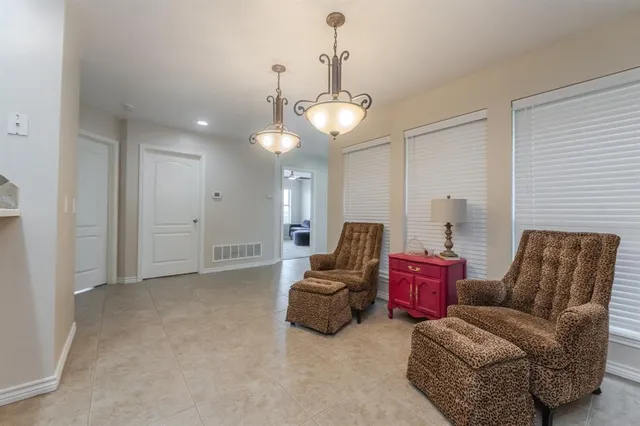 a living room with furniture a chandelier and a window