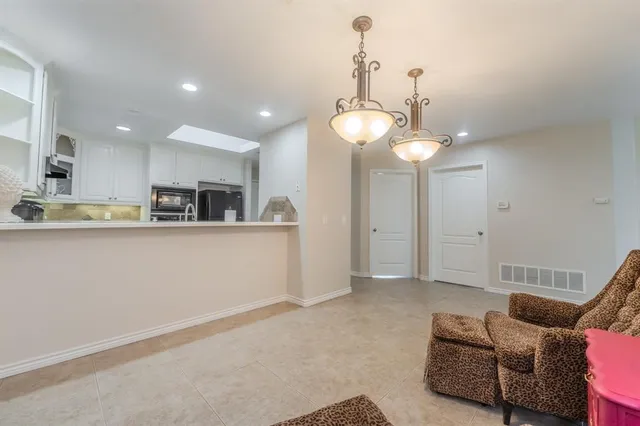 a view of kitchen with stainless steel appliances granite countertop living room