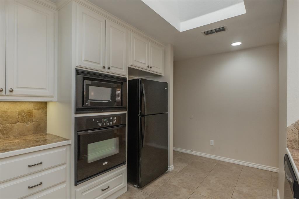 6027 Oakmont Drive Wichita Falls, TX 76310 - Photo 21 of 40 a kitchen with white cabinets and refrigerator