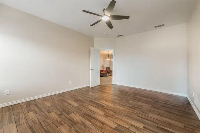 a view of an empty room with wooden floor