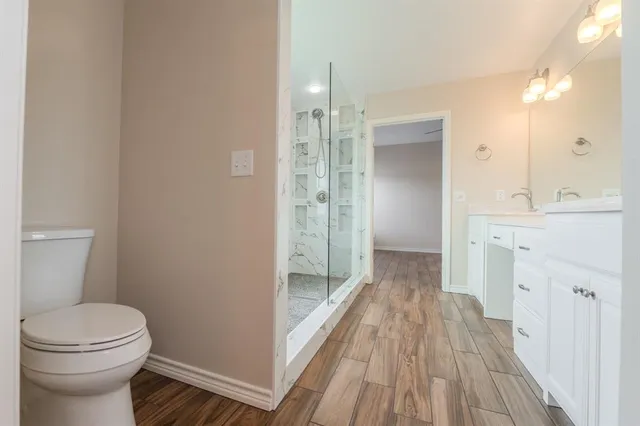 a bathroom with a sink a toilet and shower