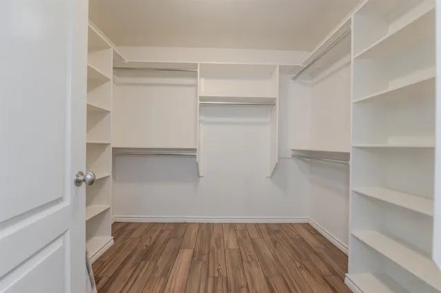 a view of walk in closet with wooden floor