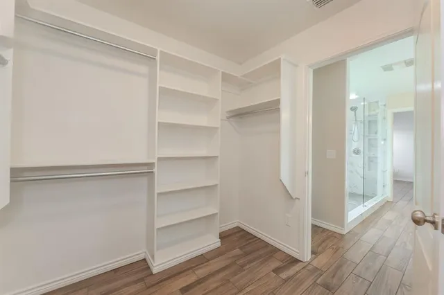 a view of walk in closet with empty racks