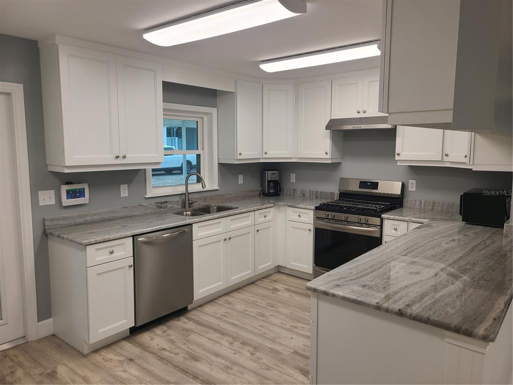 500 Coker Road Fort Pierce, FL 34945 - Photo 4 of 15 a kitchen with granite countertop white cabinets and appliances