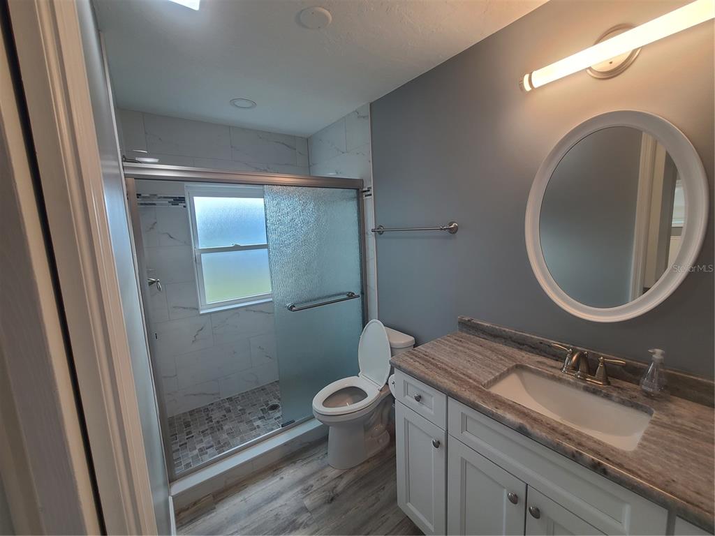 500 Coker Road Fort Pierce, FL 34945 - Photo 8 of 15 a bathroom with a granite countertop toilet a sink and a mirror