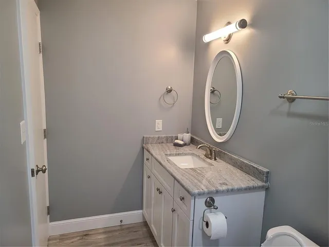 a bathroom with a granite countertop sink and a mirror