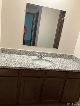 a bathroom with a granite countertop sink and a mirror