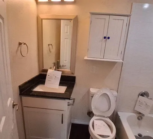 a white toilet sitting next to a bath tub