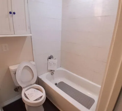 a bathroom with a granite countertop sink a toilet and a mirror