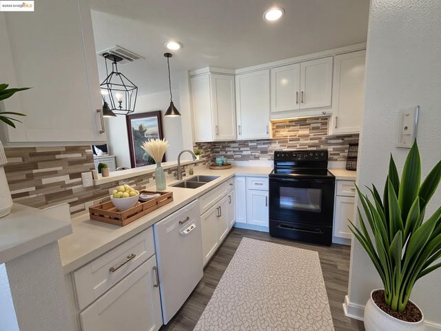 a kitchen with kitchen island granite countertop a sink a stove and refrigerator