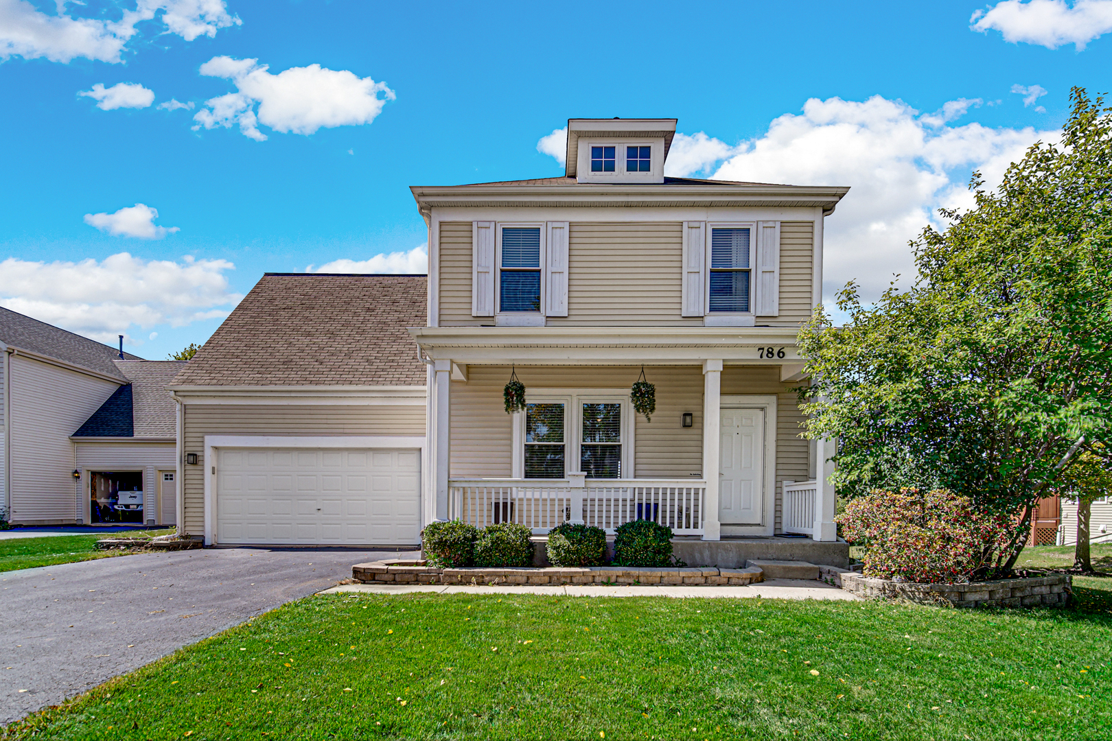 a front view of a house with a garden and plants