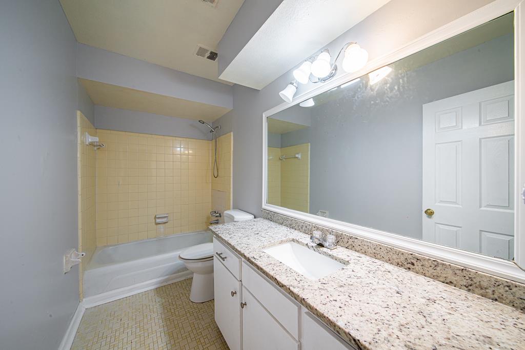 4 Clausen Drive Columbus, GA 31907 - Photo 20 of 27 a bathroom with a granite countertop sink a toilet a large mirror and shower