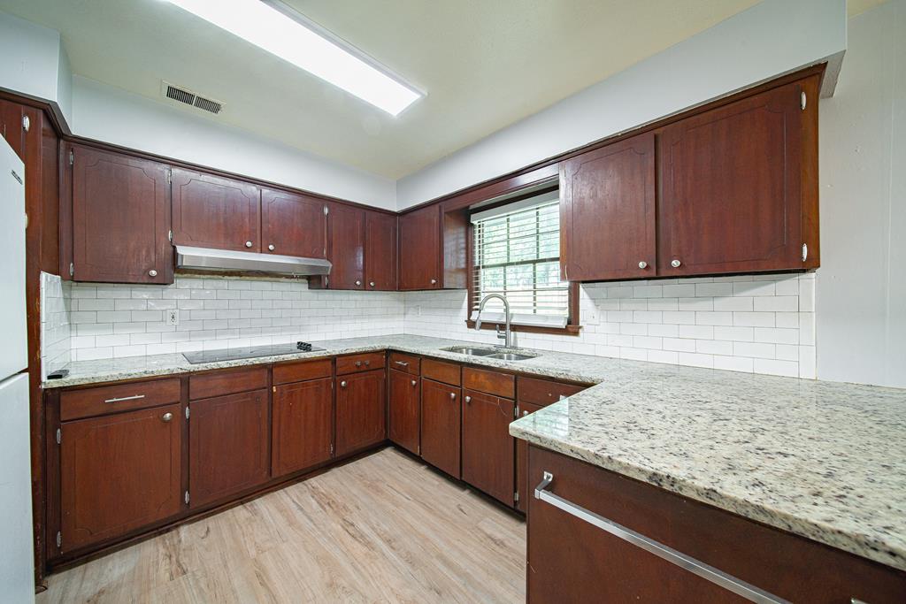4 Clausen Drive Columbus, GA 31907 - Photo 9 of 27 a kitchen with granite countertop wooden cabinets a sink and dishwasher