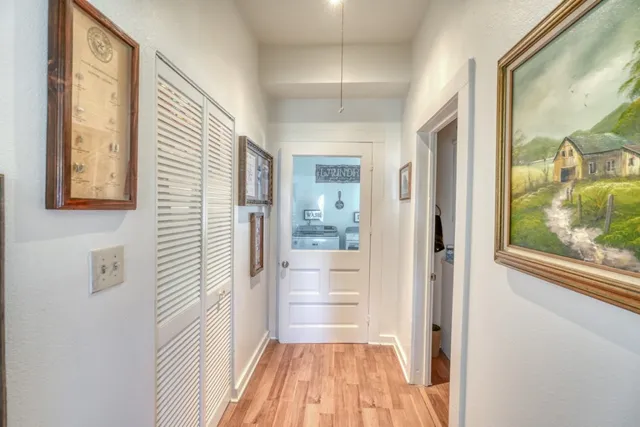 a view of a hallway with wooden floor and windows