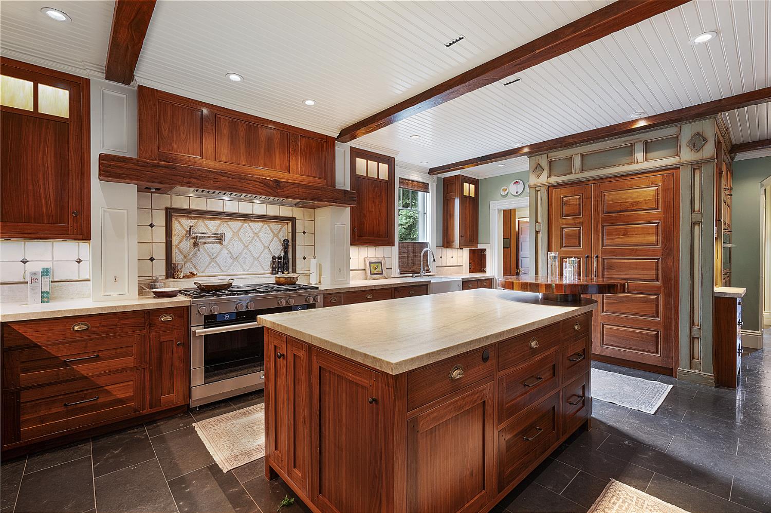 6533 Landis Avenue Carmichael, CA 95608 - Photo 24 of 77 This kitchen is a masterclass in refined luxury and uncompromising quality, anchored by a full suite of professional-grade Miele appliances. A built-in refrigerator and freezer are seamlessly concealed behind custom walnut panel fronts, complementing the commanding 8-burner gas range with double ovens, pasta faucet, and commercial-grade ventilation hood.