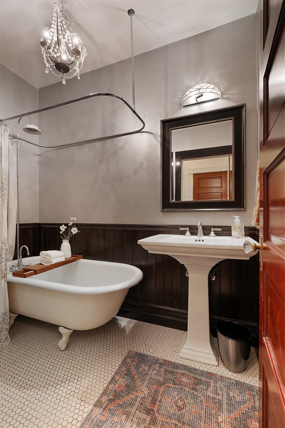 6533 Landis Avenue Carmichael, CA 95608 - Photo 53 of 77 This is one of two full bathrooms located on the main level. The clawfoot tub, pedestal sink, and whimsical chandelier come together to create a charming, cohesive space with distinctive character.
