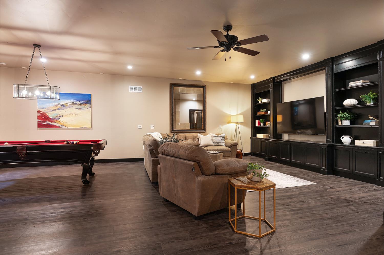 6533 Landis Avenue Carmichael, CA 95608 - Photo 56 of 77 The lower-level entertainment retreat is thoughtfully designed for leisure and social gatherings, offering approximately 1,000 square feet of finished space. It comes equipped with a pool table and two televisions, along with a built-in entertainment center that enhances the space’s functionality and appeal. A convenient half bathroom is included, and the entire area is fully heated and cooled. Additionally, the space is plumbed for a wet bar, providing the potential for an upgraded hosting experience.