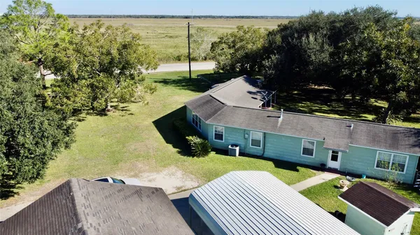 an aerial view of a house with a yard and lake view