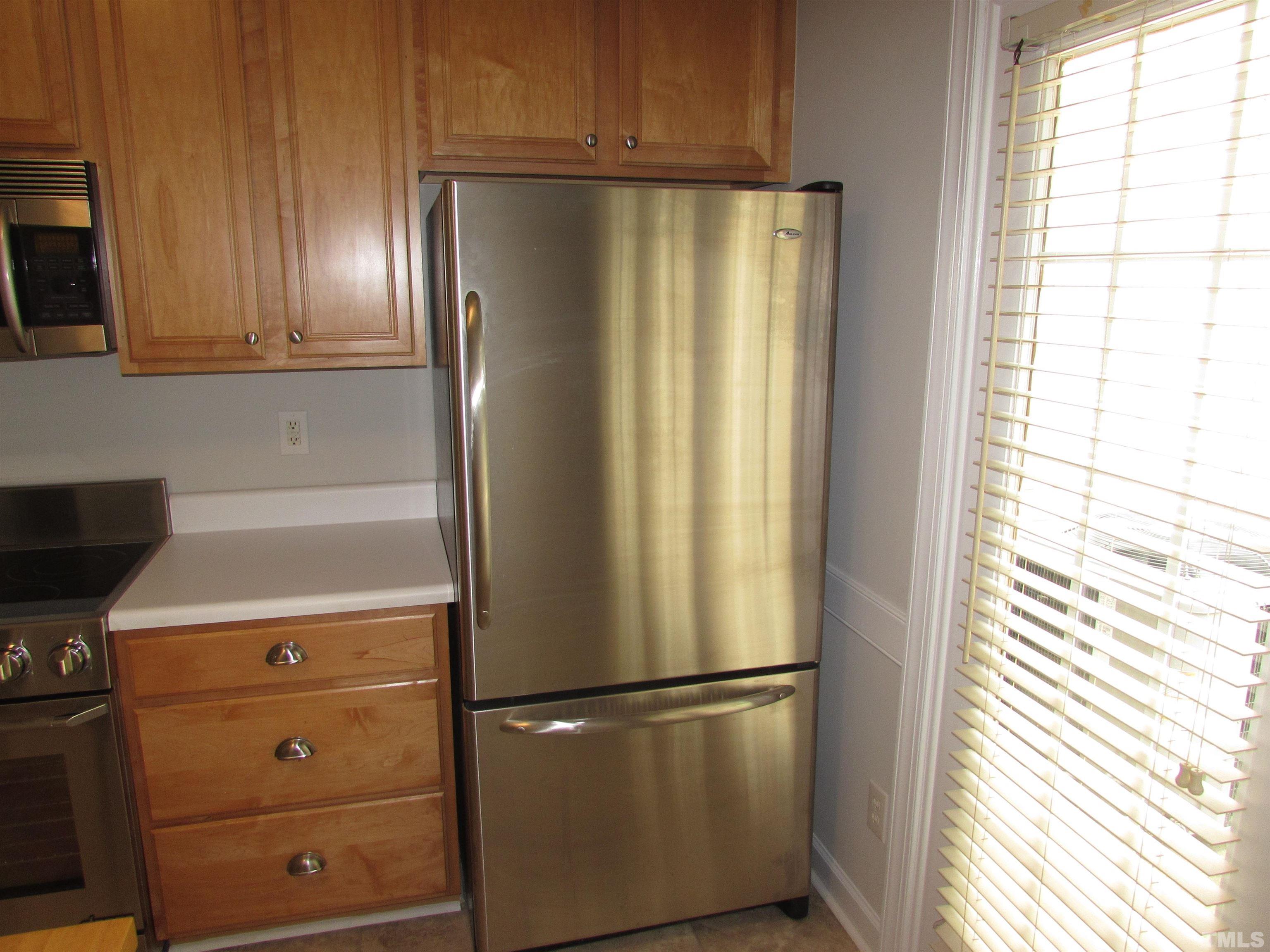 802 Rothshire Court Raleigh, NC 27615 - Photo 12 of 29 a white refrigerator freezer and a stove sitting inside of a kitchen