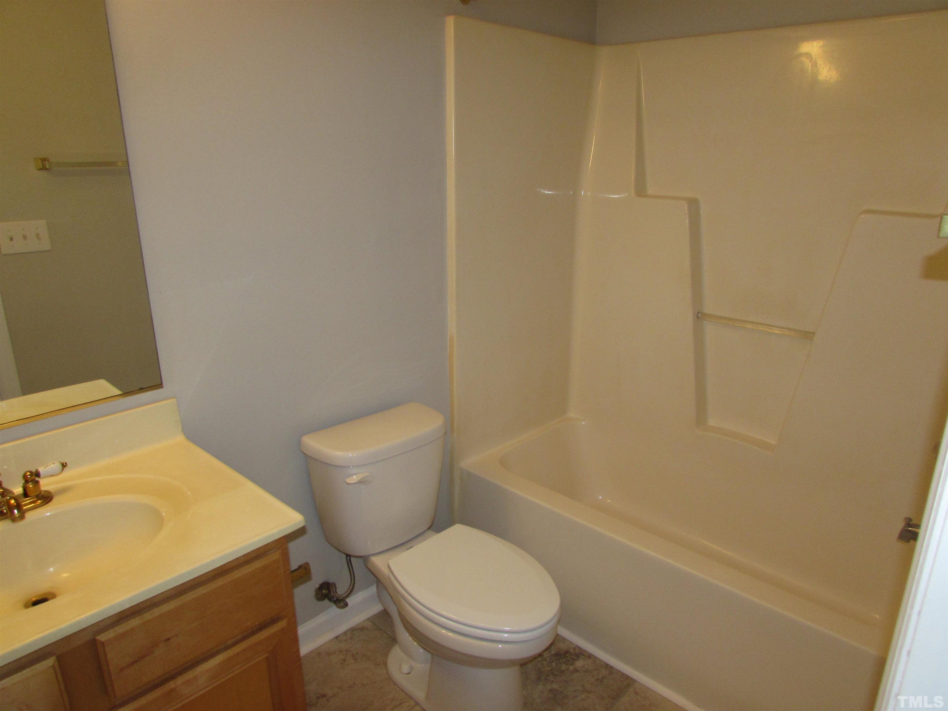 802 Rothshire Court Raleigh, NC 27615 - Photo 22 of 29 a white toilet sitting next to a bathroom sink and vanity