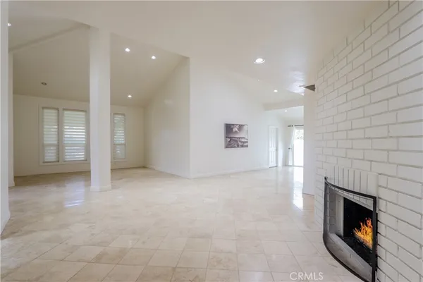 an empty room with windows and fireplace