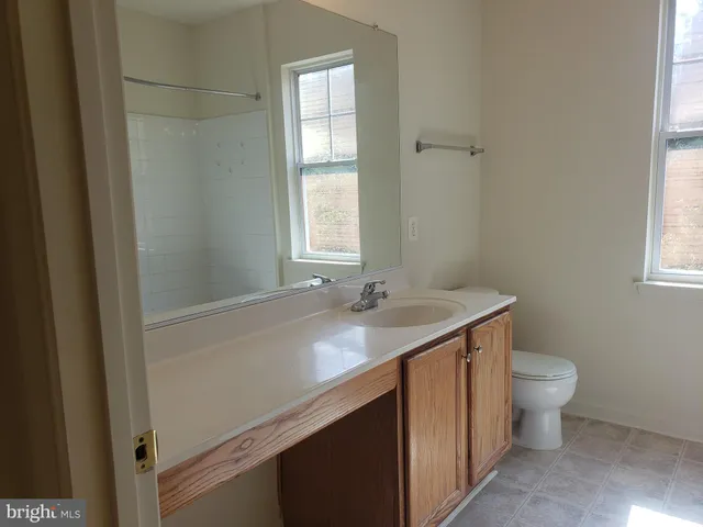 a bathroom with a sink toilet and window