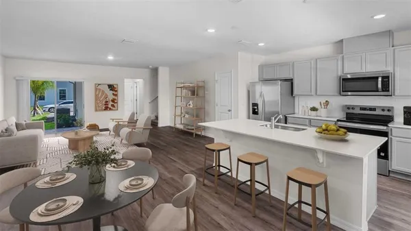 a kitchen with stainless steel appliances granite countertop a dining table and chairs
