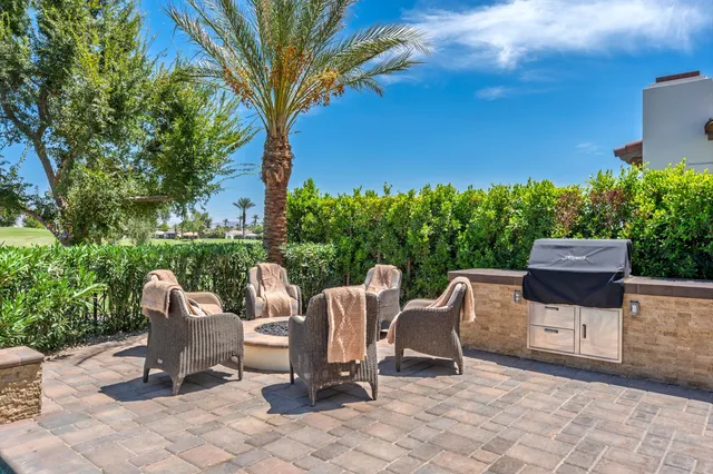 a view of a lake with couches and table and chairs under an umbrella