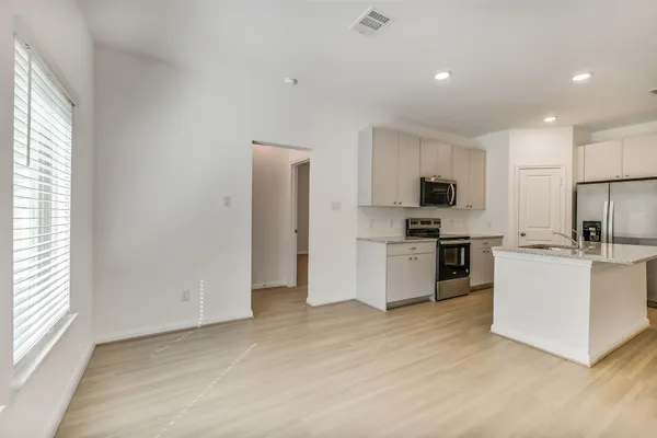 a kitchen with white cabinets and stainless steel appliances