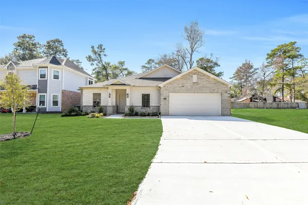 a front view of a house with a garden and yard