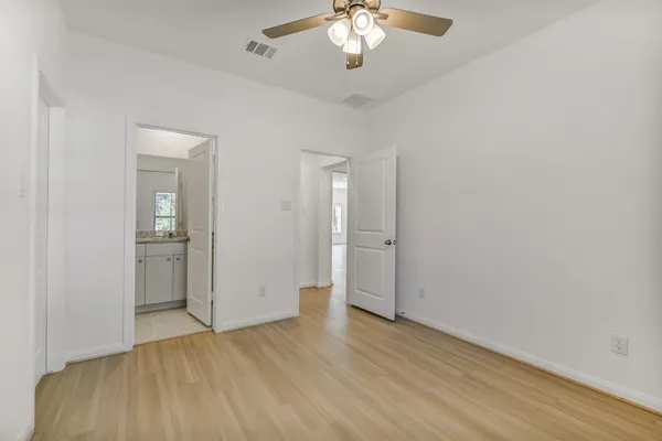 an empty room with wooden floor and a chandelier