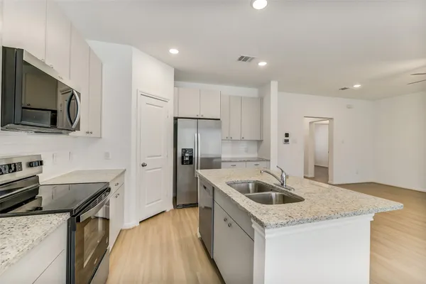 a kitchen that has a sink a stove top oven a refrigerator and dishwasher with wooden floor