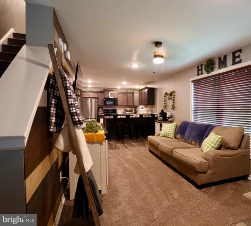 a kitchen with stainless steel appliances kitchen island granite countertop a sink dishwasher stove and refrigerator with wooden floor