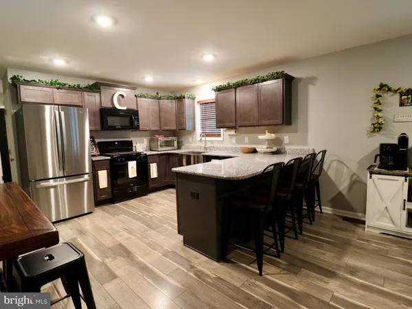 a kitchen with granite countertop stainless steel appliances a sink stove and microwave