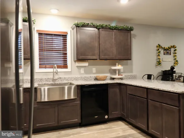 a kitchen with granite countertop a sink a stove and cabinets