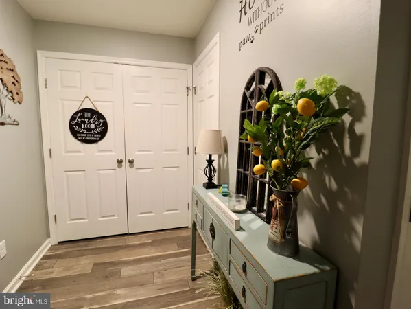 a view of a hallway with wooden floor and a living room
