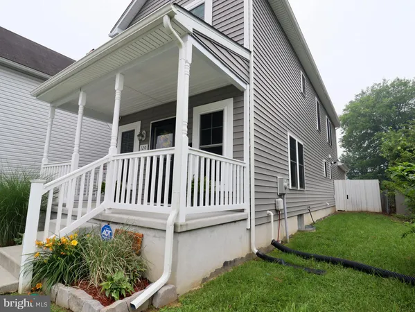 a view of a house with a small yard and wooden fence