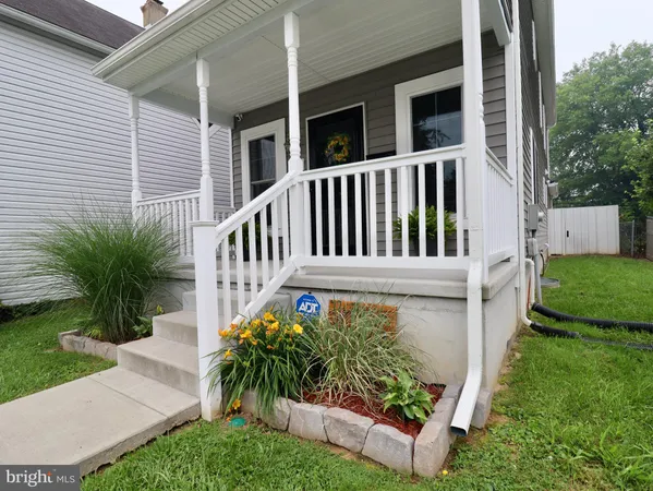 a front view of a house with a yard and potted plants